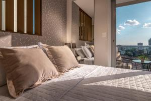เตียงในห้องที่ ÚNICO - Stay & Residences by AVA