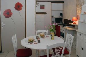 uma cozinha com uma mesa branca com flores em Gtes Aux Portes de lEure Les Coquelicots em Vernon