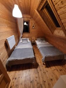 a room with three beds in a wooden cabin at Dom Nad Stawem Dłużec 55A in Mrągowo