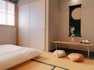 una camera con letto, tavolo e porta di suikakan heianjingumae 酔花間 a Kyoto Altre 58 foto