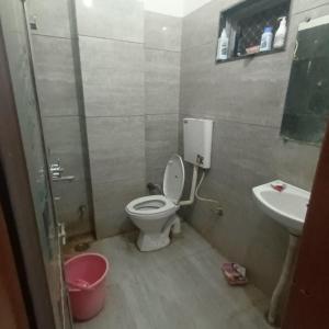 a bathroom with a toilet and a sink at VTP Guest House in Bikaner