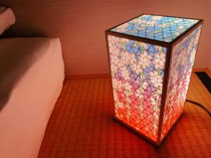 una scatola di vetro sul pavimento accanto a un letto di suikakan heianjingumae 酔花間 a Kyoto