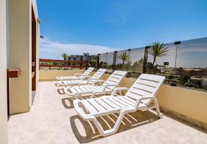 - une rangée de chaises longues blanches sur un balcon dans l'établissement Hotel Casa de la Luna, à Chiclayo
