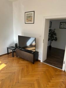 a living room with a flat screen tv and a wooden floor at dreams Düsseldorf in Düsseldorf +7 photos