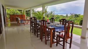 une salle à manger avec une table et des chaises sur une terrasse couverte dans l'établissement Villa 'The Blue House' - Qbungalows, à Kep