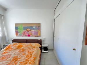 カンヌにあるLe Colonyのベッドルーム1室(ベッド1台付)が備わります。壁には絵画が飾られています。