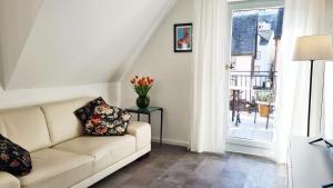 a living room with a couch with a vase of flowers at Weinstock - klimatisierte Ferienwohnung mit Sonnenterrasse in Reil