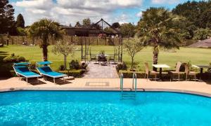 a swimming pool with chairs and a table and a patio at B&B Casa Roman & Vakantiewoning voor 1 pers tot max 32 personen in Zonhoven