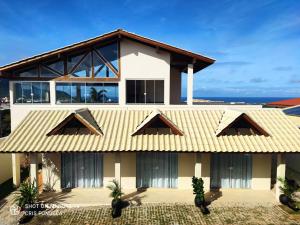 Hospedagem MAR SANTO في فلوريانوبوليس: منزل بسقف اصفر وبعض النباتات