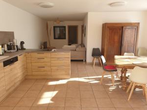 una cocina con armarios de madera, mesa y sillas en Luciole des Alpilles, en Mouriès 5 fotos más