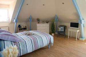 a bedroom with a bed and a dresser and a television at Les Hauts de Fondanger in Cublac