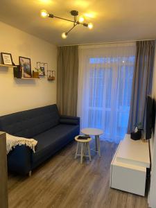 a living room with a blue couch and a table at Harmony Apartman BB in Banská Bystrica