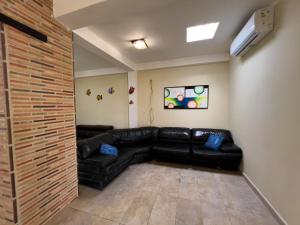 salon z czarną skórzaną kanapą w pokoju w obiekcie Tucacasposadas w mieście Tucacas