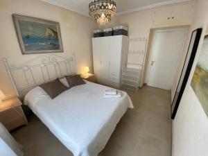 マラガにあるLa Union Malagaのベッドルーム(白いベッド1台、シャンデリア付)