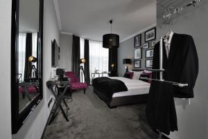 a bedroom with a bed and a table and a mirror at Hotel Friends Hückelhoven in Hückelhoven