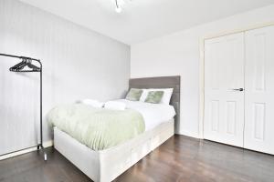 a white bedroom with a bed and a white door at StayRight Spacious 5-Bed House with Parking - 15 mins from City Centre! in Cardiff