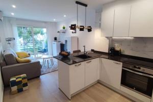 een keuken met witte kasten en een woonkamer bij Casa Capitolio - Albir in Albir