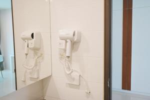 een badkamer met twee telefoons aan de muur bij Herry Residence in Chiang Mai