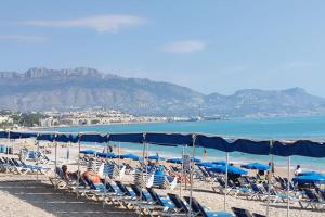 een groep stoelen en parasols op een strand bij Casa Capitolio - Albir in Albir
