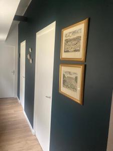 a hallway with three framed pictures on a wall at Péniche logement d'exception sur la Seine Spécial JEUX OLYMPIQUES in LʼÎle-Saint-Denis