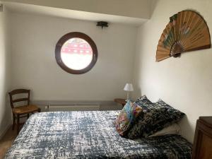 a bedroom with a bed and a window at Péniche logement d'exception sur la Seine Spécial JEUX OLYMPIQUES in LʼÎle-Saint-Denis