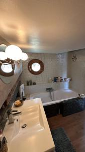 bagno con lavandino e vasca di Péniche logement d'exception sur la Seine Spécial JEUX OLYMPIQUES a LʼÎle-Saint-Denis