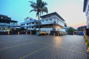 een parkeerplaats met een palmboom en een gebouw bij Park Residency in Cochin