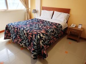 1 dormitorio con 1 cama y 1 mesa con teléfono en SAN ANDRES en Ipiales