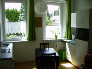 a kitchen with a table and two windows and a table and chairs at Allsaitig Klang- und Seminarzentrum Selb in Selb