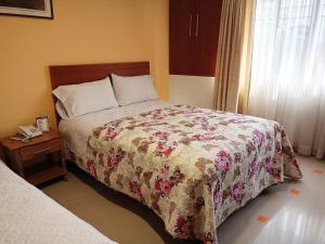 Un dormitorio con una cama y un teléfono en una mesa. en SAN ANDRES en Ipiales