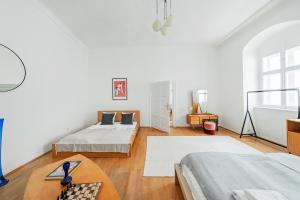 een witte kamer met 2 bedden en een tafel bij Hidden Gem with red Door in Wenen
