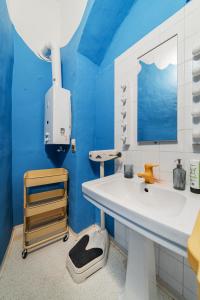 een badkamer met een witte wastafel en een blauwe muur bij Hidden Gem with red Door in Wenen