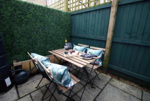 a table and chairs with pillows on a patio at Bath Luxury City Centre 4 Bedroom Townhouse, Sleeps 8, Easy Parking, Private Courtyard Garden, by EMPOWER HOMES in Bath
