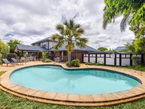 a swimming pool in front of a house at 4BR German style Villa w Pool Eight Mile Plains in Brisbane