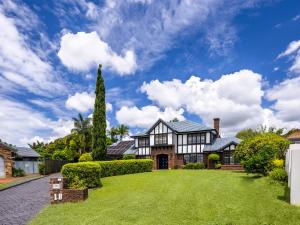 dom z zielonym trawnikiem przed nim w obiekcie 4BR German style Villa w Pool Eight Mile Plains w mieście Brisbane