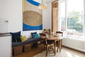 ロンドンにあるBright Talbot Road Apartmentのダイニングルーム(テーブル、ソファ付)