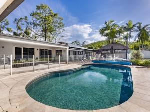 an image of a swimming pool in front of a house at Modern 4BR Holiday Home W Pool BBQ Oxenford in Gold Coast