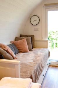 uma cama num quarto com um relógio na parede em Secluded Luxury Pod with Hot Tub em Launceston