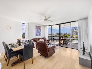 uma sala de estar com uma mesa e uma sala de jantar em Stylish 2BR Haven in West Ends Vibrant Heart em Brisbane