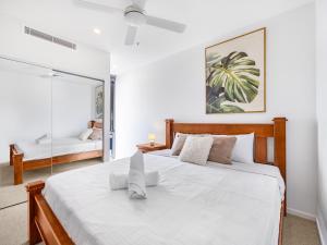 um quarto com uma grande cama branca e um espelho em Stylish 2BR Haven in West Ends Vibrant Heart em Brisbane