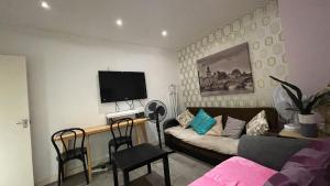 a living room with a couch and a flat screen tv at Room available near Edgware Road London in London