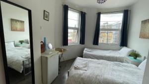 a bedroom with two beds and a mirror at Room available near Edgware Road London in London