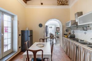 a kitchen with a table and chairs and a refrigerator at House & Villas - Casa di Lucia in Noto