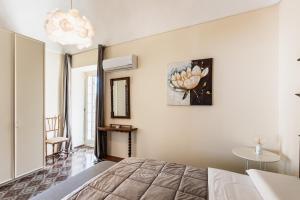 1 dormitorio con 1 cama y una pintura en la pared en House & Villas - Casa di Lucia en Noto