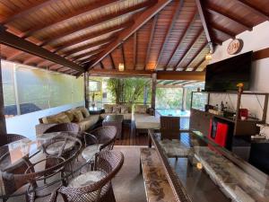 uma sala de estar com um sofá e uma mesa em Casa Feliz no Jardim Itaipava, 7 quartos, conforto em Itaipava