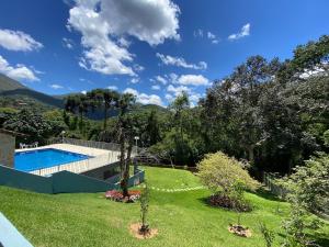 a backyard with a swimming pool and a grass yard at Casa Feliz no Jardim Itaipava, 7 quartos, conforto in Itaipava