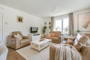 a living room with two couches and a tv at Huswell - A luminous apartment near the marina in Ostend