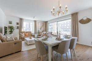 - un salon avec une table et des chaises blanches dans l'établissement A luminous apartment near the marina, à Ostende
