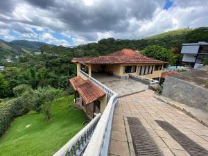 uma casa com uma varanda com um quintal relvado em Casa Feliz no Jardim Itaipava, 7 quartos, conforto em Itaipava
