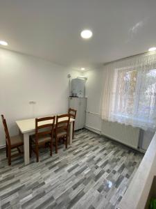 La cuisine est équipée d'une table, de chaises et d'un réfrigérateur. dans l'établissement SorinaApartament, à Tîrgu Neamţ